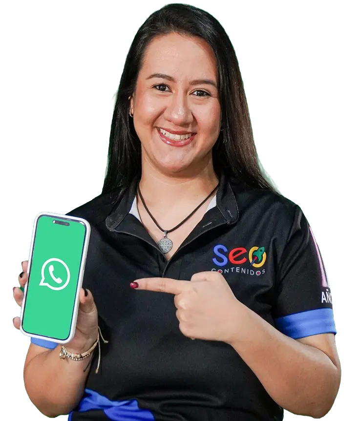 Mujer sonriente señala un teléfono móvil con el logo de WhatsApp, promoviendo contacto directo para consultas.